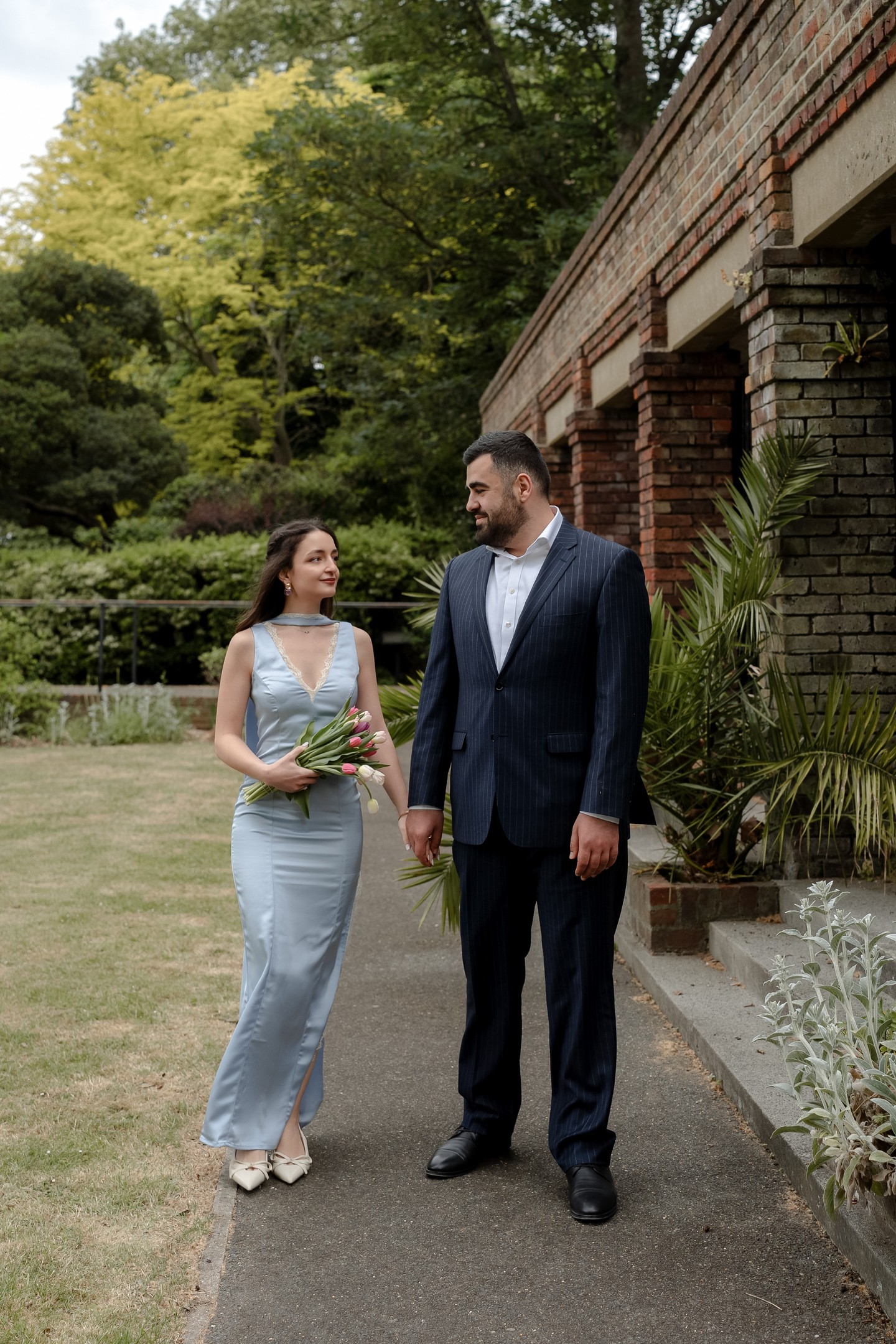 Maneh and Grisha holding hands in the garden